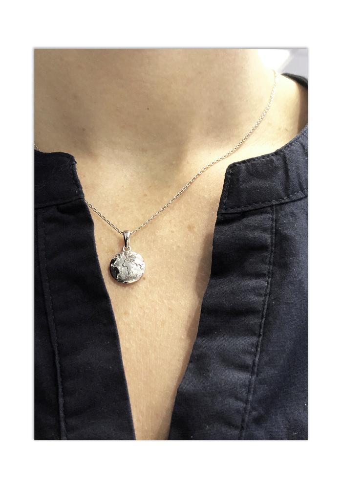 Pendentif planète terre en argent sterling sur le cou d'une femme
